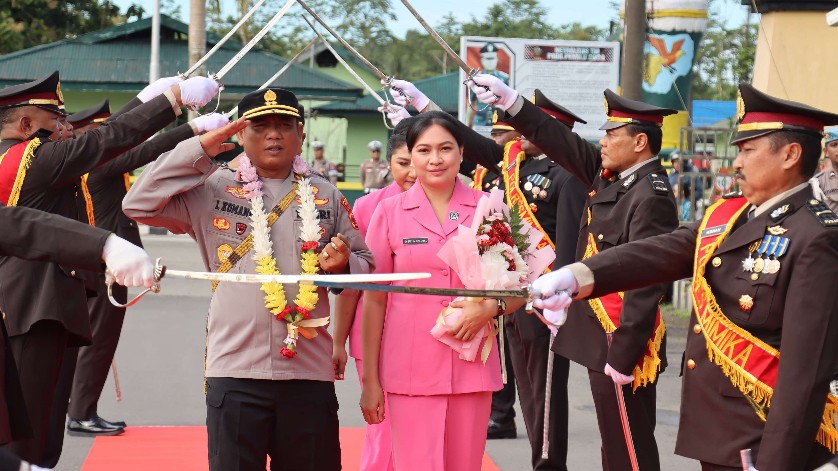 Kapolres Mimika AKBP I Komang Budiartha bersama istri  disambut pedang pora saat memasuki Mako Polres Mimika. Foto: Humas Polres Mimika