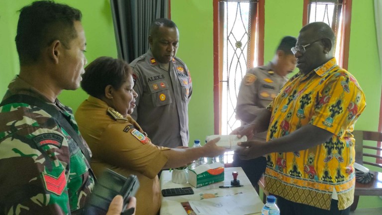 Kadistrik Mimika Timur Jauh, Priska Kuum menyerahkan uang tunai bantuan PKH kepada kepala kampung di Jalan Kesehatan, Senin (23/3/2026). Foto: Burhan/ Papua60detik