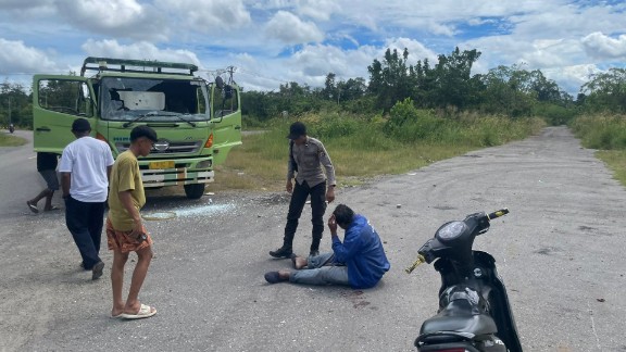 Polisi mendatangi TKP pengeroyokan dan pelemparan kaca truk kontainer di Pomako, dimana korban berinisial DYR masih terduduk pada Senin (4/5/2026) siang. Foto: Polsek Mimika Timur