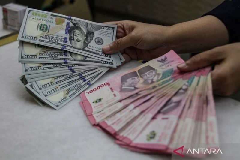 Karyawan menunjukkan uang pecahan rupiah dan dolar Amerika Serikat (AS) di gerai penukaran mata uang asing Ayu Masagung, Kwitang, Jakarta. Foto: ANTARA FOTO/Darryl Ramadhan/wsj. (Darryl Ramadhan)