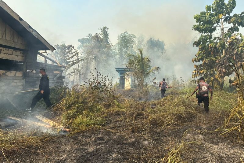 Personel kepolisian saat berusaha memadamkan api yang sudah mendekati pemukiman warga di Distrik Nabire Barat, Jumat (21/8/2026). ANTARA/HO-Humas Polda Papua Tengah
