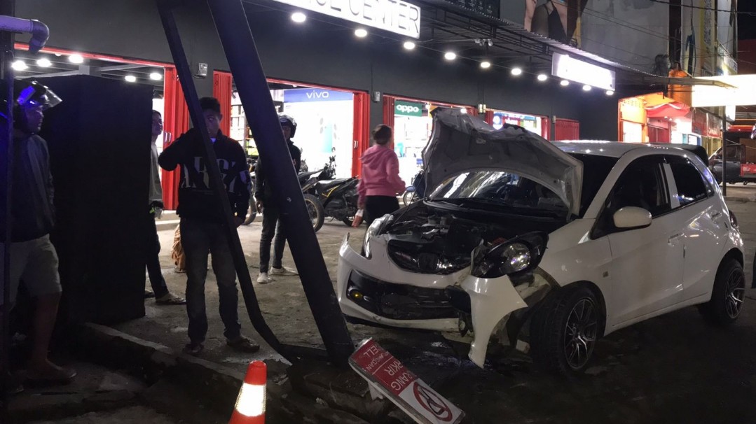 Mobil Brio putih rusak parah usai menabrak tiang iklan di Jalan Budi Utomo, Timika Papua, Minggu (16/10/2022) malam. malam. Foto: Faris/ Papua60detik