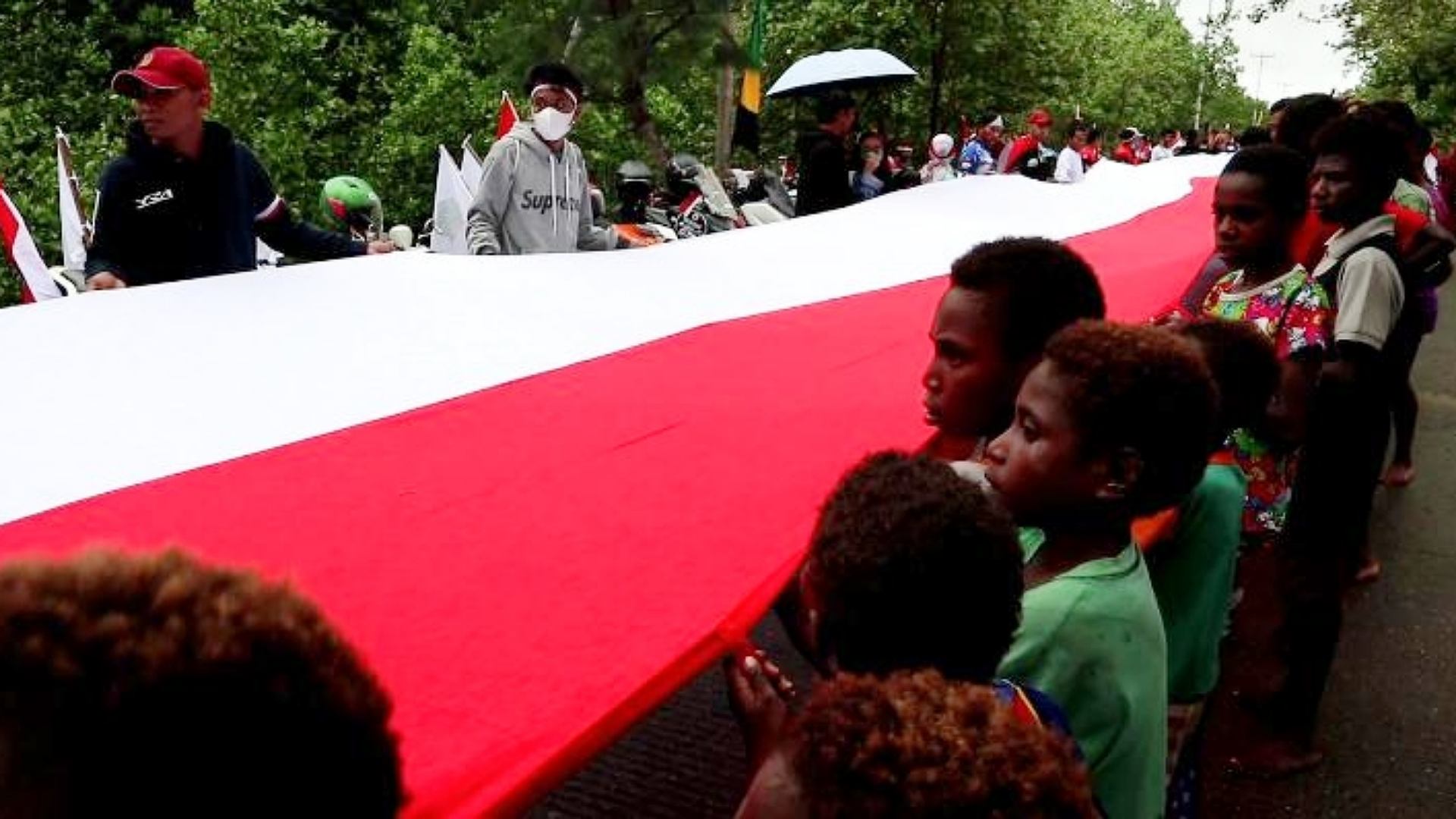 warga-mimika-bentangkan-bendera-merah-putih-77-meter-di-jembatan-pomako