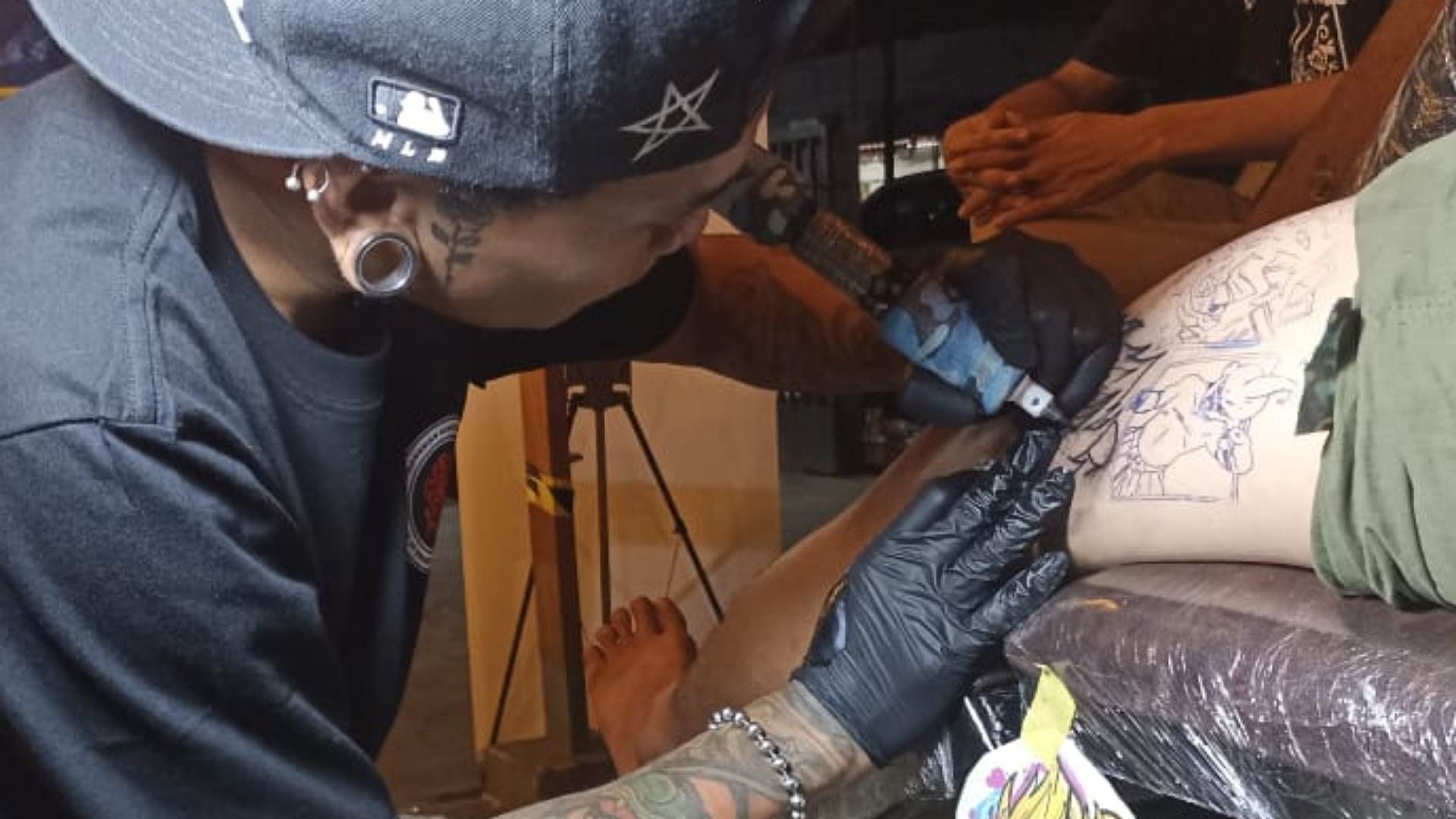 Customer saat sedang ditato oleh Pace Kasta. Foto: Eka/ Papua60detik